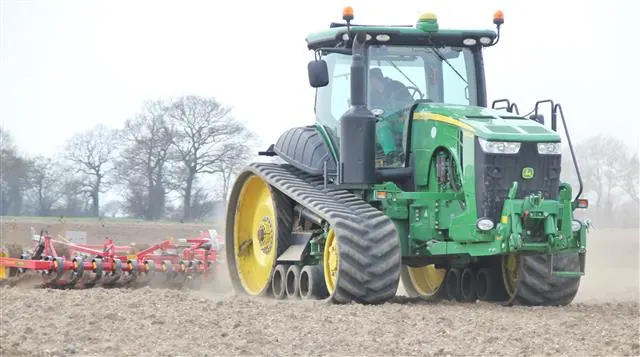 Tractor on tracks preparing a field